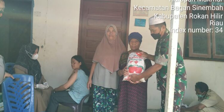 Dampingi Nakes Vaksin Door To Door, Babinsa Serahkan Bantuan Sembako
