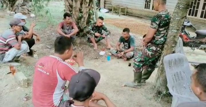 Disela Waktu Istirahat, Anggota Satgas TMMD Komsos dengan Warga