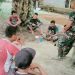 Disela Waktu Istirahat, Anggota Satgas TMMD Komsos dengan Warga